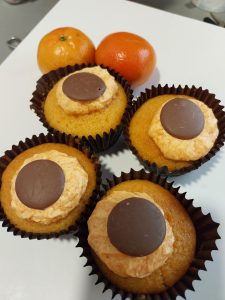 Cup cakes decorated with orange icing.