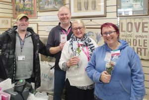 Small group of people holding flower posies.