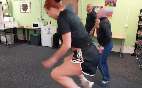 A fitness class in progress with people jumping in the air.